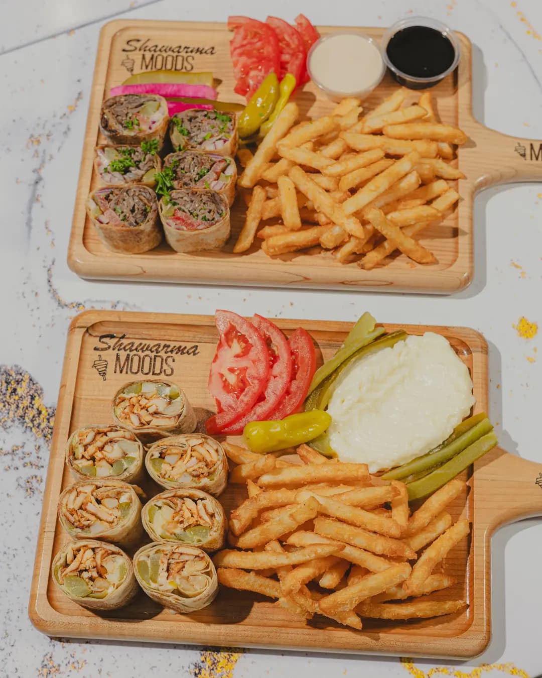 Two boards of saj wraps with fries and sauces